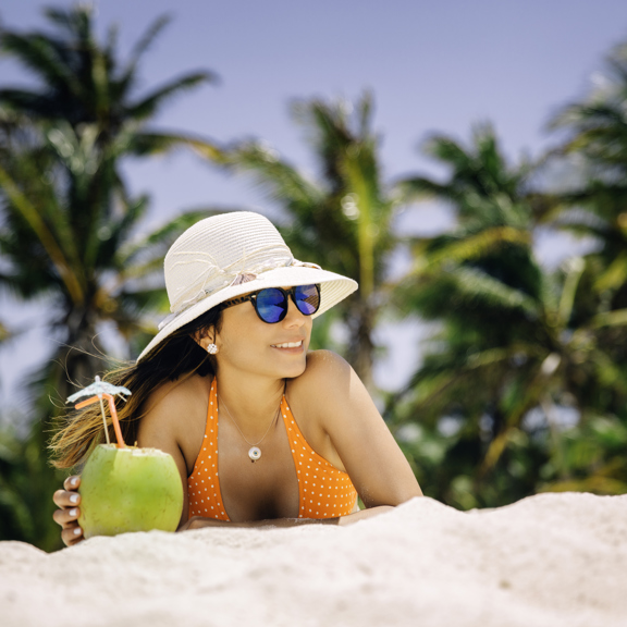 ココナッツ カクテルを持つビーチの女性