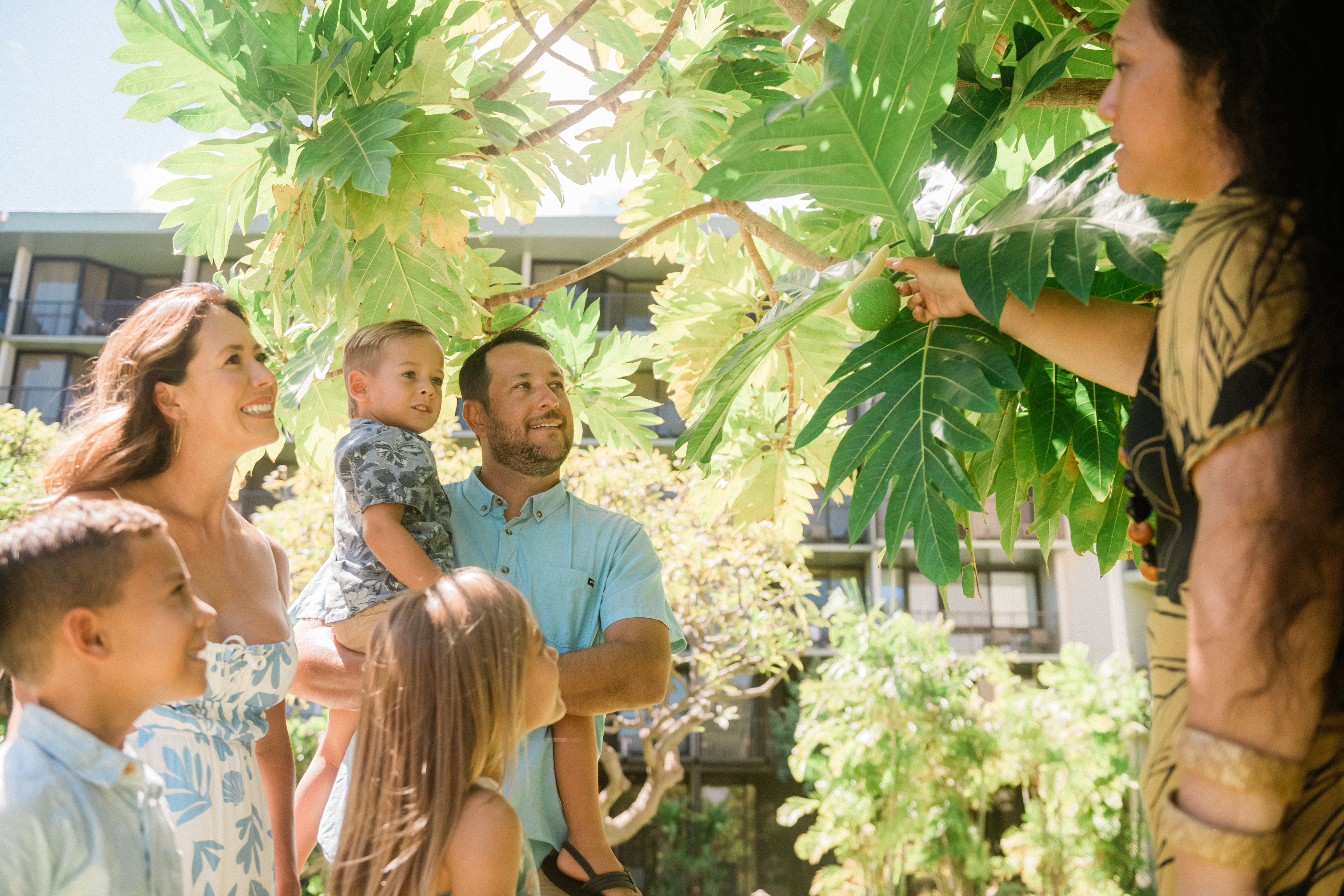 Family listening to a host teach them about the ulu (breadfruit) tree